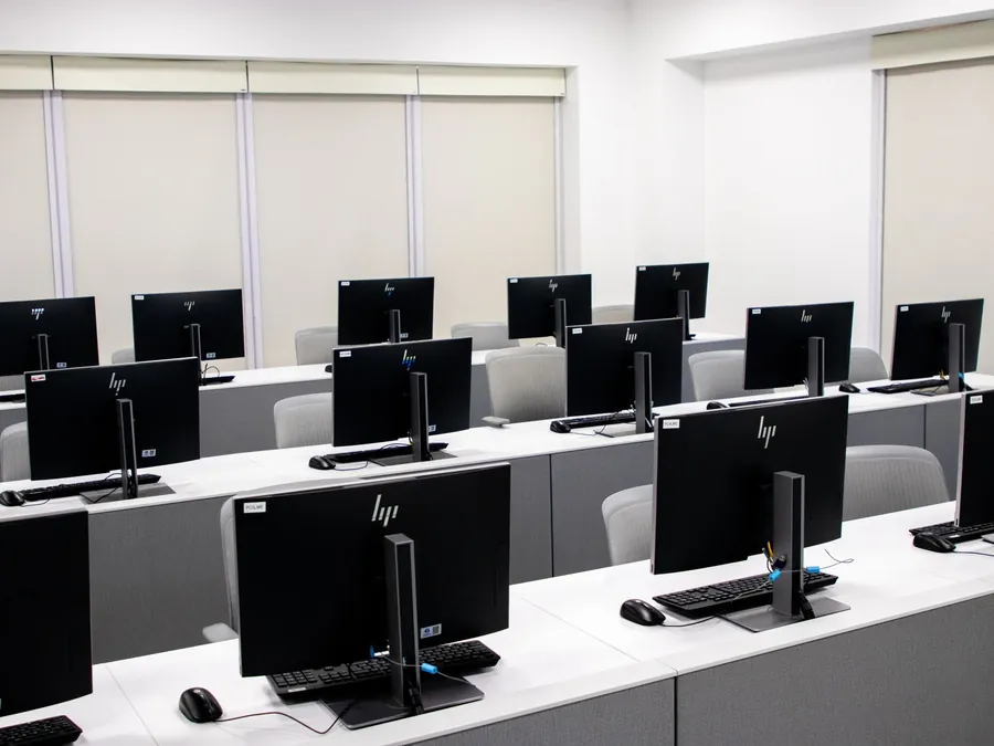 Rangée de postes informatiques fixes avec leurs écrans